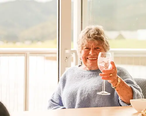 Elderly Woman Toasting Infront Of Water