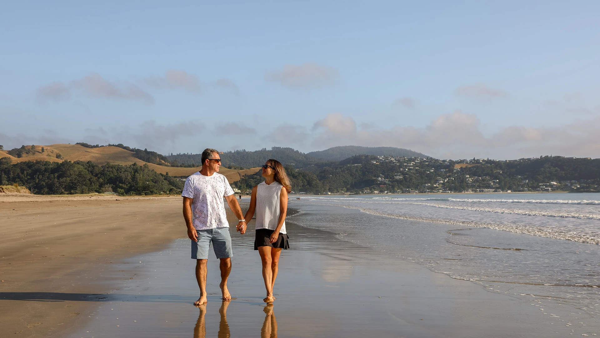 Couple walking on the beach at sunrise