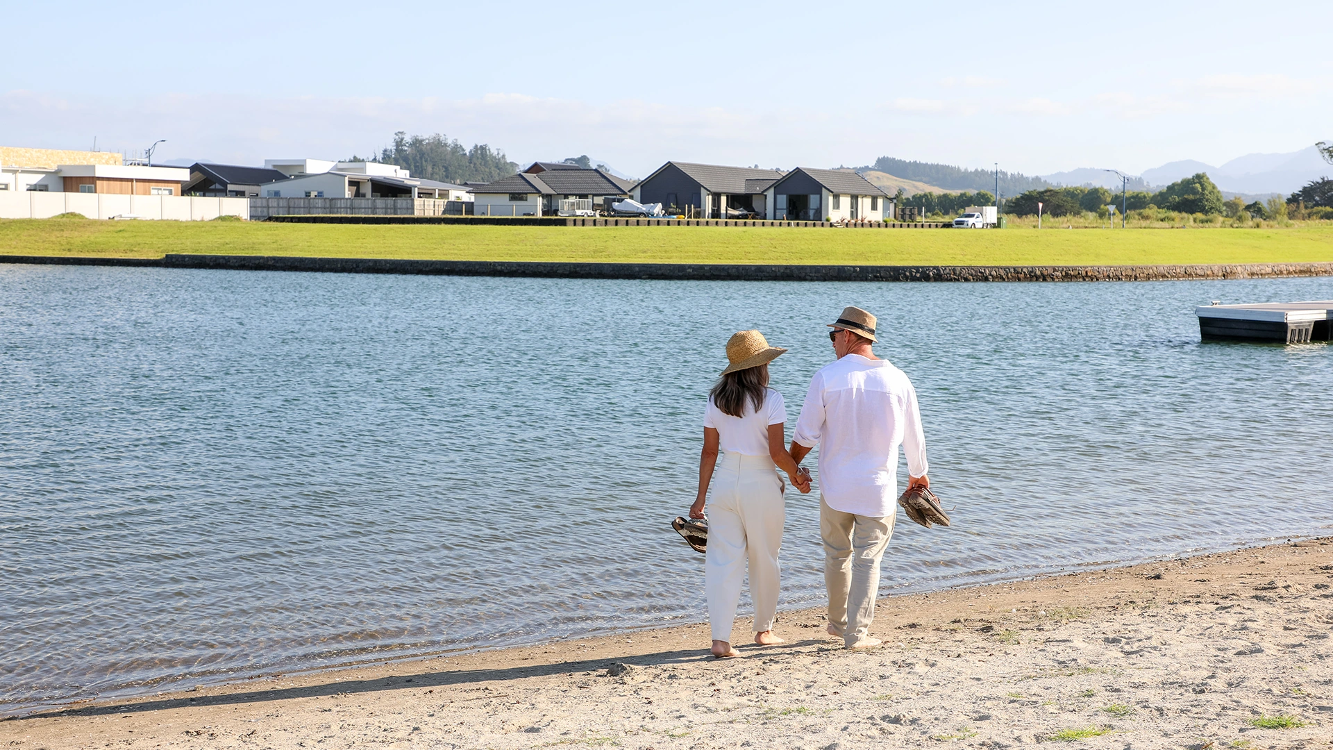 Couple holding hands walking along beach