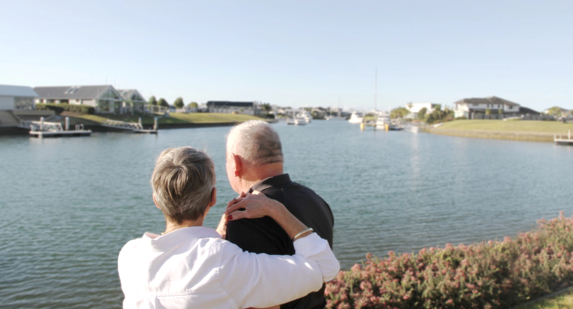 Mature couple embracing overlooking the water